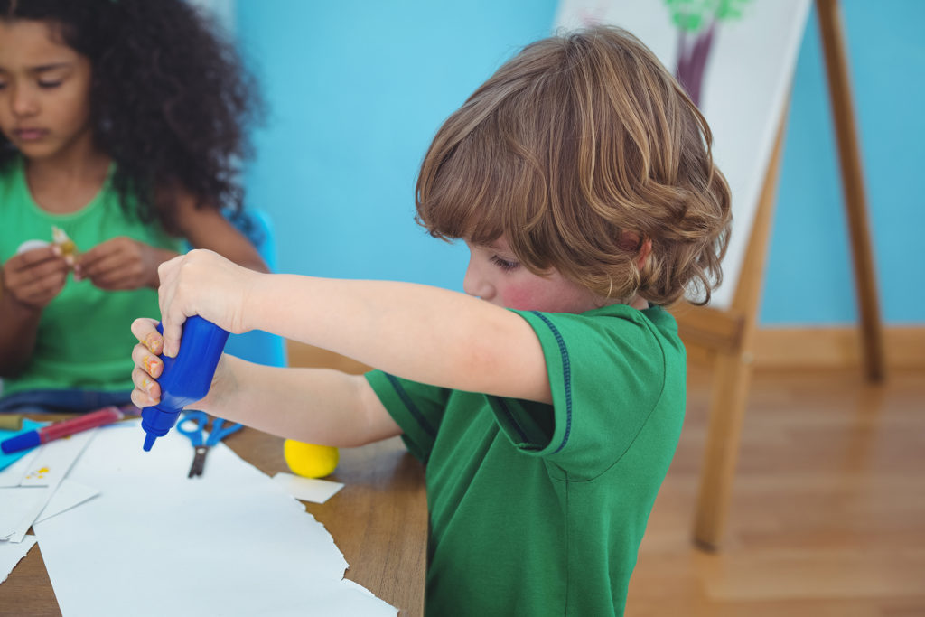 Boy using a pot of glue