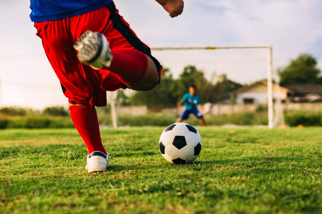 Young boy kicking football