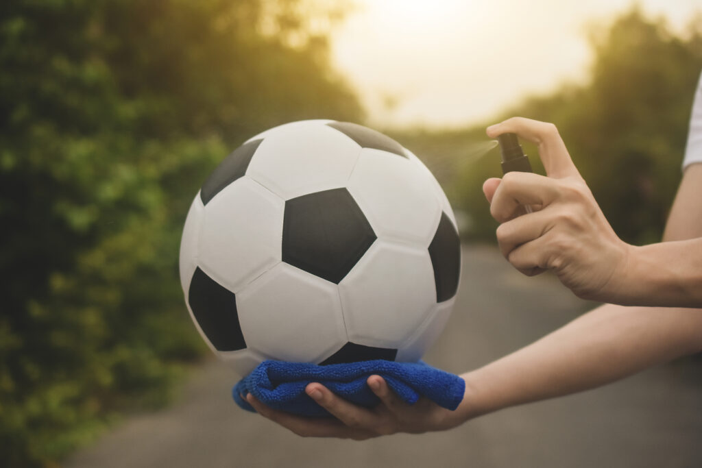 Player disinfecting a football