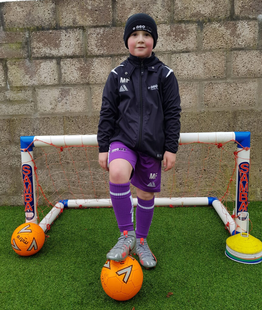 Young boy in Pendle training wear keeping active at home
