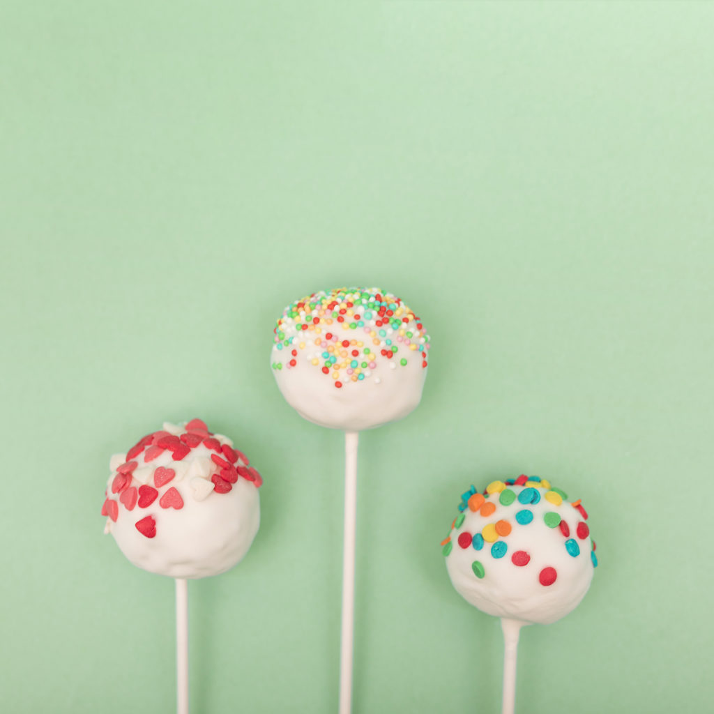 Three cake pops on green background