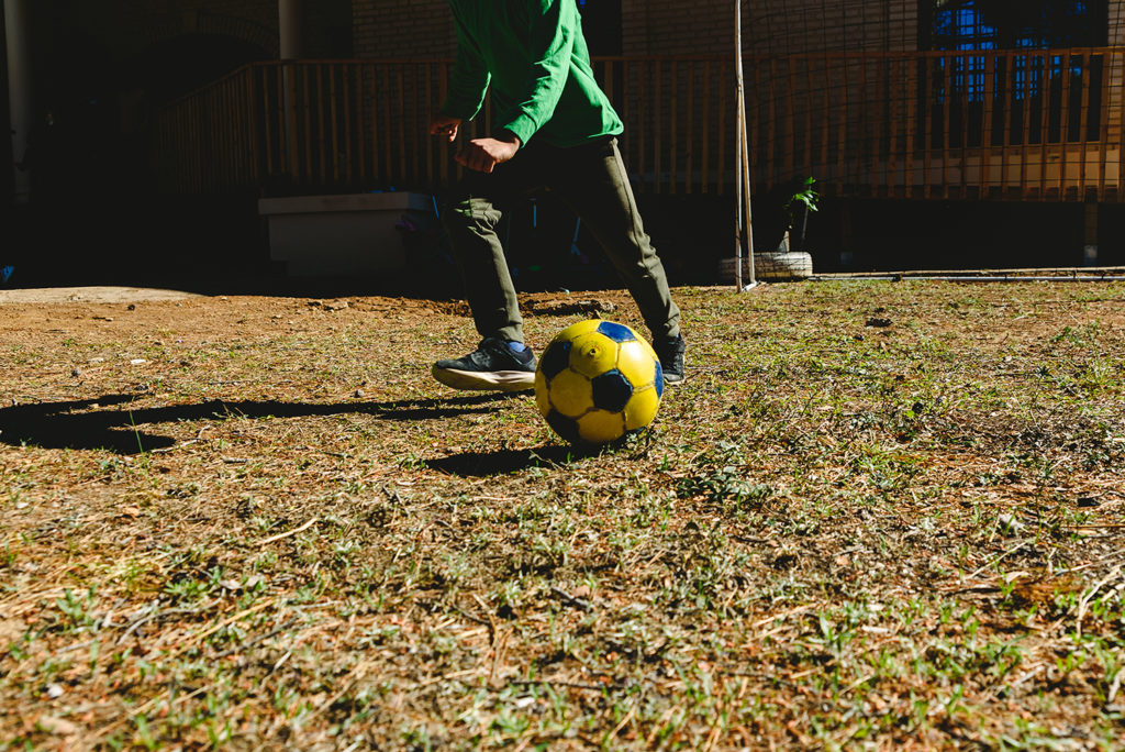 Young boy playing football in the garden