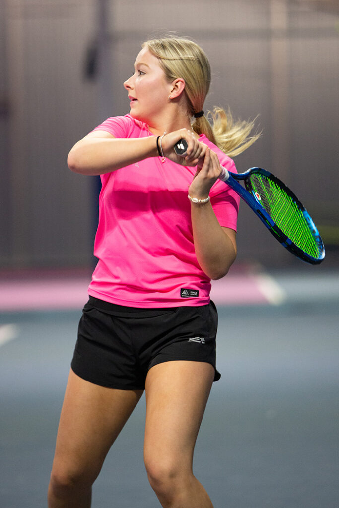 A female tennis player wearing a pink Activa tennis t-shirt