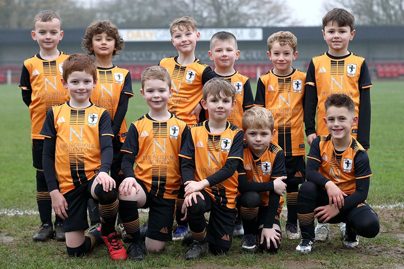 A gruop of youth football players wearing base layers under their kit.
