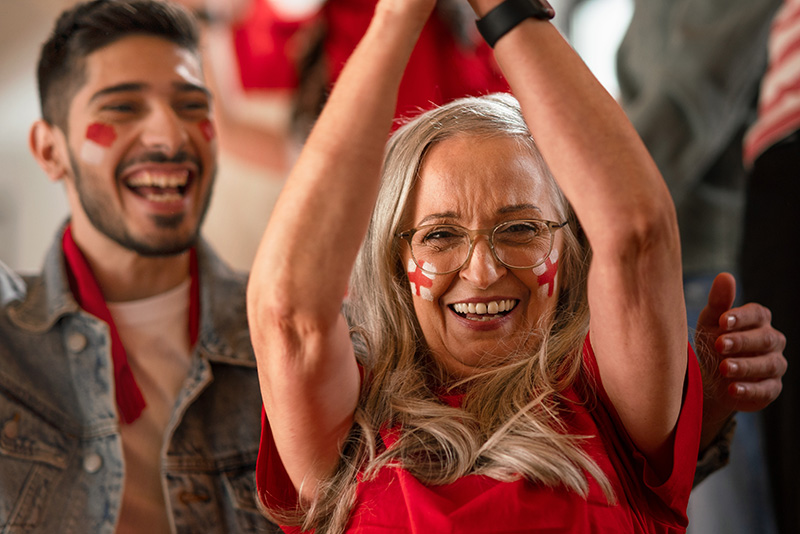 Female football fan watching football in a crowd of people