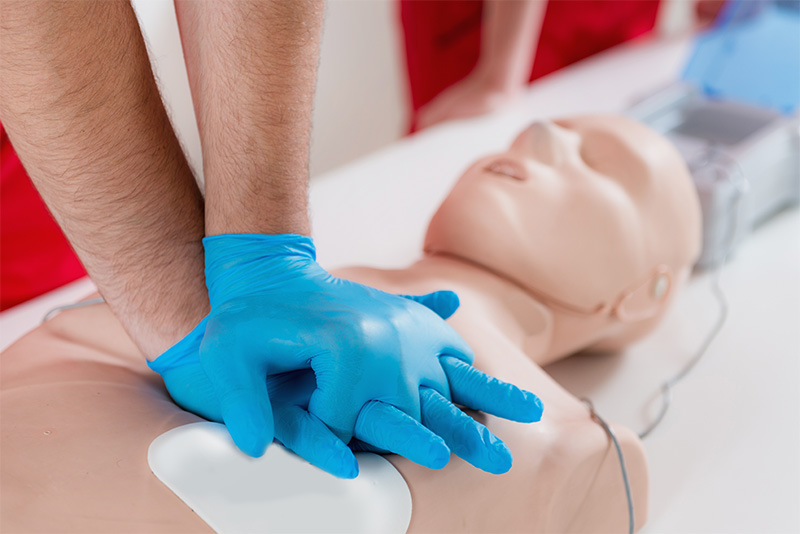 A person practicing CPR on a dummy