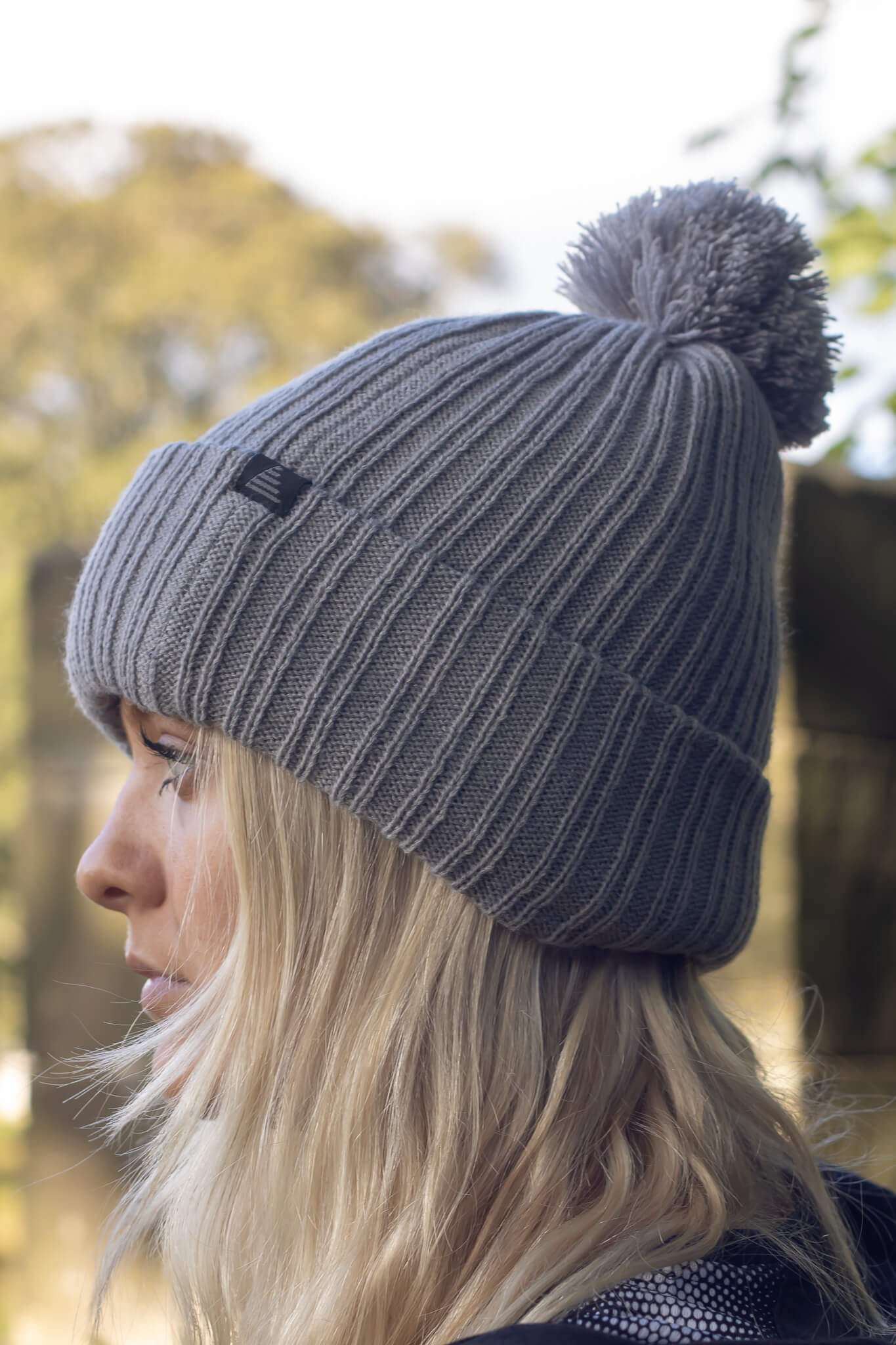 Model wearing a grey bobble hat from the Pendle Lifestyle collection.