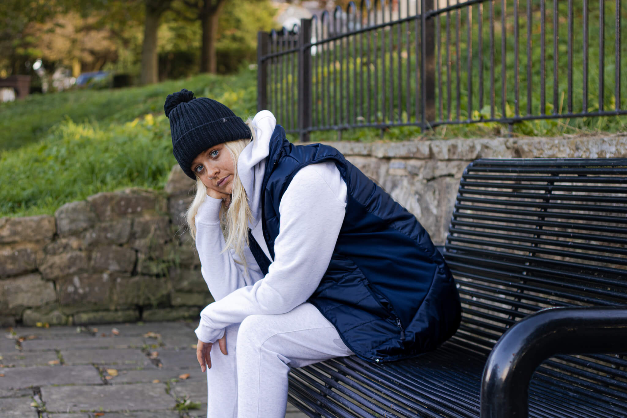 Model wearing a light grey hoodie and joggers with a navy gilet and black bobble hat from the Pendle Lifestyle collection.
