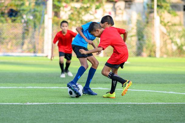 Child tackling another in a football game