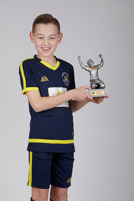 Young player holding a Pendle football trophy