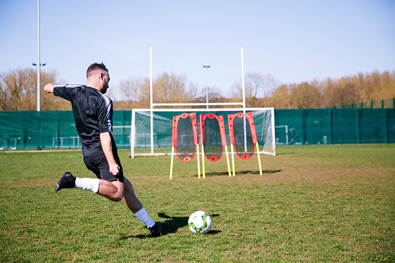 Player taking a free kick during football training