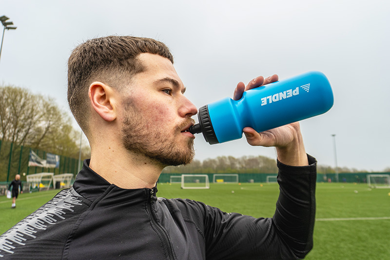 Footballer drinking from a Pendle water bottle