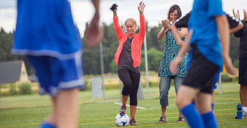 Parental role in youth football - two mothers cheering on their children