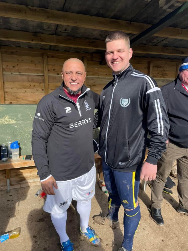 A player from Harlescott Rangers wears a Pendle tracksuit and football kit as he poses next to Roberto Carlos