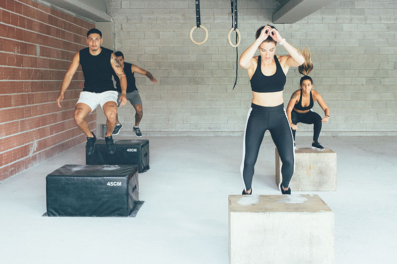 Plyometric training - men and women doing box jumps