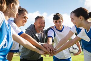 Young football players stacking their hands together