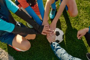 Junior Football Players Putting Hands Together in a Circle