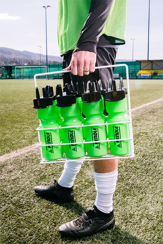 Footballer carrying a set of Pendle water bottles