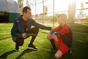 Coach giving support to young footballer